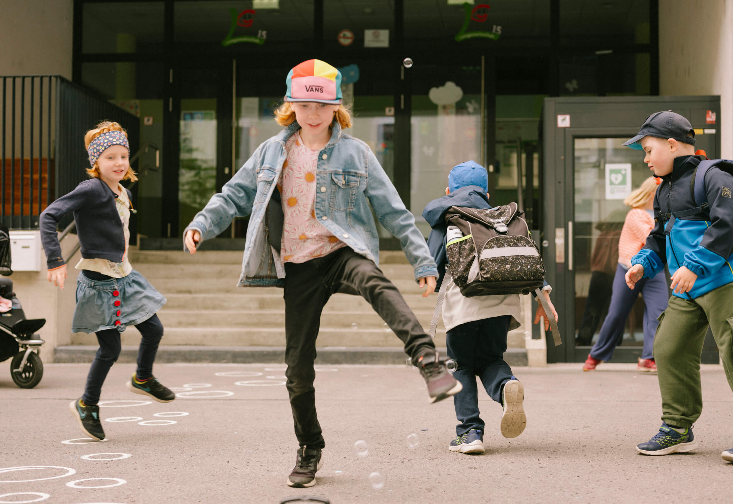 Kinder spielen vor einer Schule